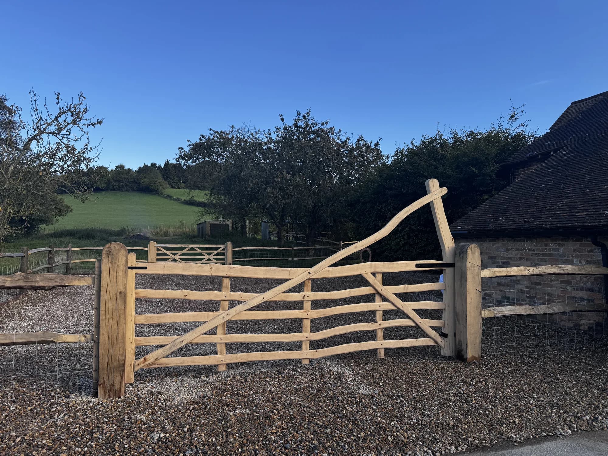 curved rising-top five-bar gate by barn
