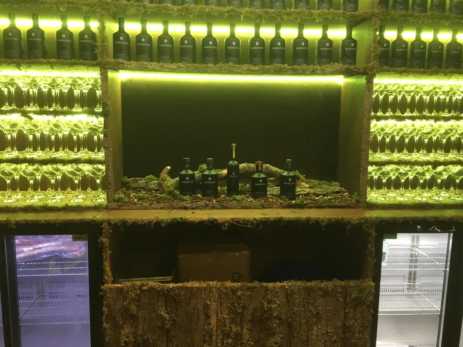 green-lit bottle shelf display